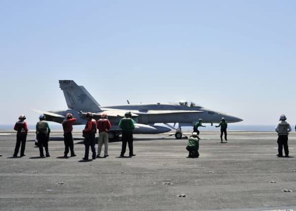 Sailors make final inspections on an F/A-18C Hornet on a US aircraft carrier. Picture: Reuters