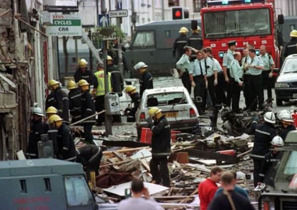 Royal Ulster Constabulary police officers and firefighters inspecting the damage caused by a bomb explosion in Market Street, Omagh, Co Tyrone, Northern Ireland. Picture: PA