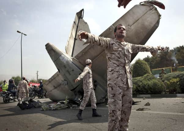 Revolutionary Guards stand watch over part of the wreckage of the passenger jet that crashed in Tehran. Picture: AP