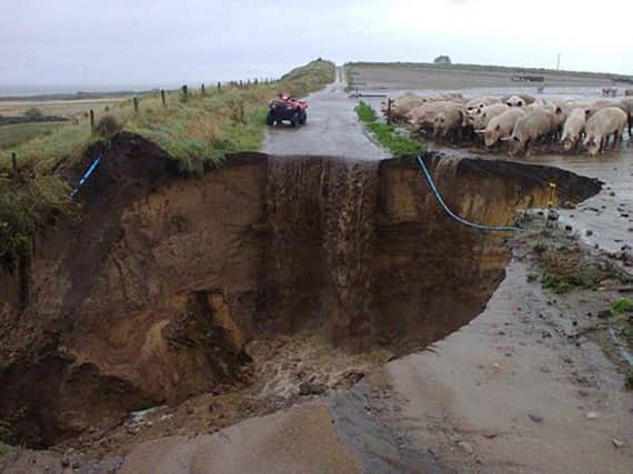 A hole in the road near Nairn as heavy rain across the north of Scotland saw more than 30 flood warnings issued today in areas. Picture: PA