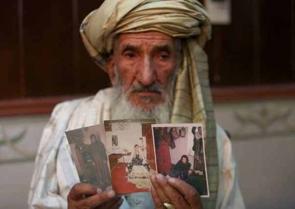 Hajji Sharfddin 67,holds photographs of relatives, who went missing , during U.S. military operations in Gardez province. Picture: AP