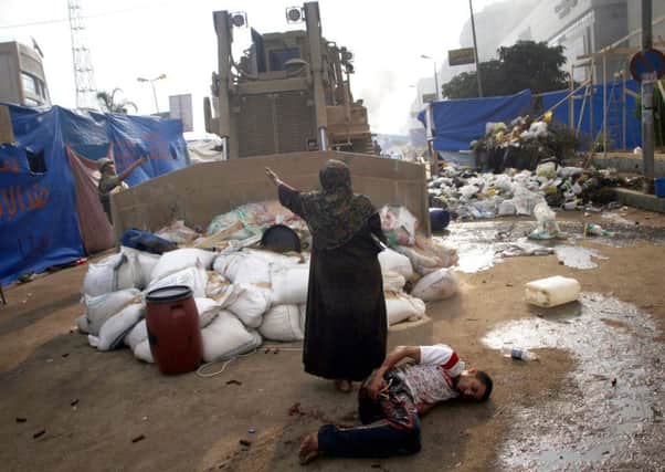 An Egyptian woman trying to stop a military bulldozer from hurting a wounded youth in clashes in 2013  Picture: AFP/Getty Images