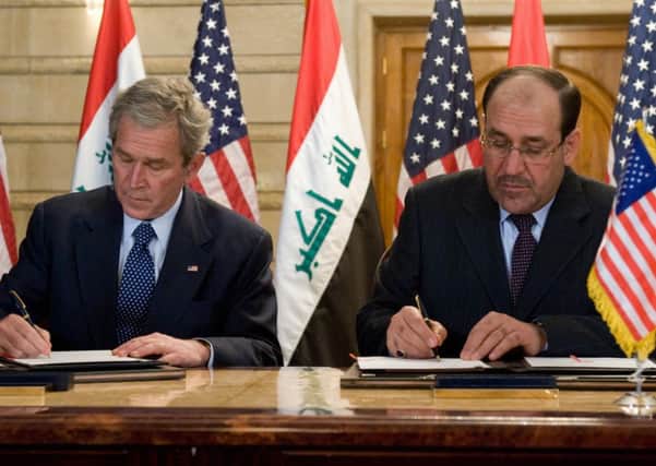George Bush and Nouri alMaliki in 2008. At an earlier signing, the Iraqi prime minister only pretended to sign the document. Picture: Getty