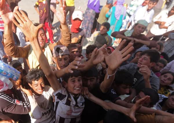 Yazidis clamour for water at a refugee camp Picture: Getty Images