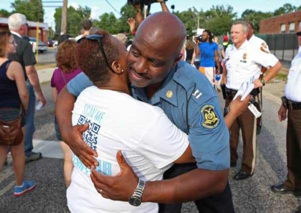 Highway Patrol Captain Ronald Johnson hugs a woman in Ferguson as tensions eased yesterday.  Picture: AP