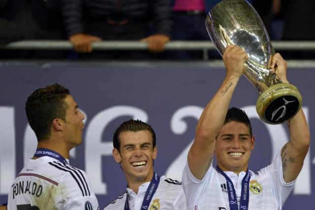 Real Madrids latest signing, James Rodriguez, centre, celebrates winning the UEFA Super Cup final with fellow galacticos Cristiano Ronaldo and Gareth Bale. Photograph: Reuters