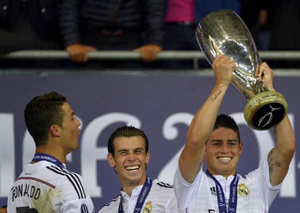Real Madrids latest signing, James Rodriguez, centre, celebrates winning the UEFA Super Cup final with fellow galacticos Cristiano Ronaldo and Gareth Bale. Photograph: Reuters
