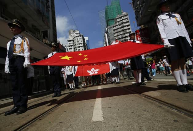 A Chinese flag and a Hong Kong flag, rear, are displayed on a pro-Beijing march yesterday. Picture: Vincent Yu