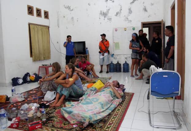 Survivors rescued after a tourist boat sank rest at a house near to the Indonesian town of Bima. Picture: Getty