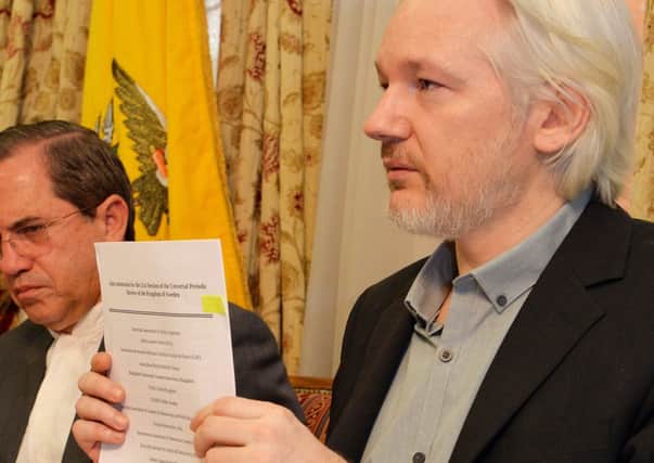 WikiLeaks founder Julian Assange  holds up a document during a press conference inside the Ecuadorian Embassy in London. Picture: Getty