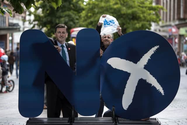 Labour shadow foreign secretary Douglas Alexander is photobombed' by a Yes campaigner in Glasgow. Picture: Wattie Cheung