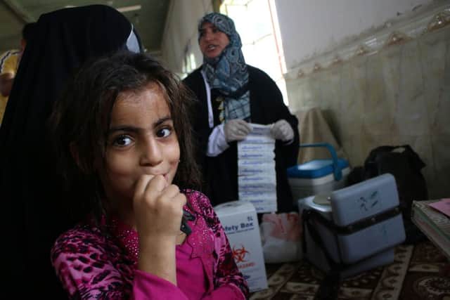 A girl who fled northern Iraq receives aid at a mosque near Basra. She is among 1.2 million Iraqis displaced by war. Picture: Reuters