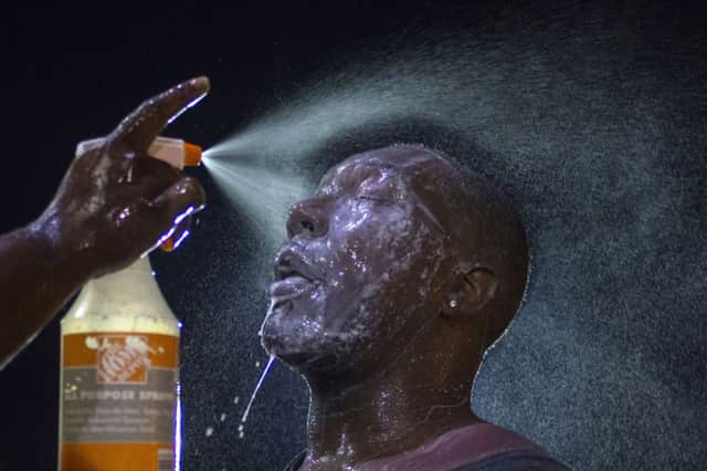 Man doused with milk and sprayed with mist to combat eye irritant from security forces. Picture: Reuters