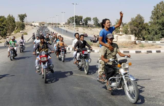 Residents of Tabqa city and Islamic State militants tour the streets in celebration after IS took over Tabqa air base. Picture: Reuters
