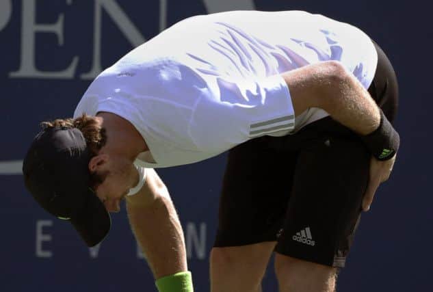 Andy Murray grimaces with pain as unexplained, unexpected cramp caused him some problems. Picture: AP