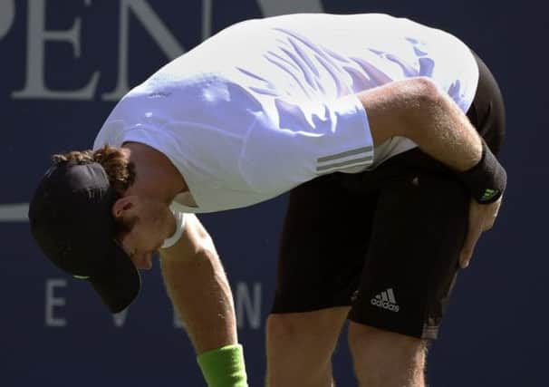 Andy Murray grimaces with pain as unexplained, unexpected cramp caused him some problems. Picture: AP