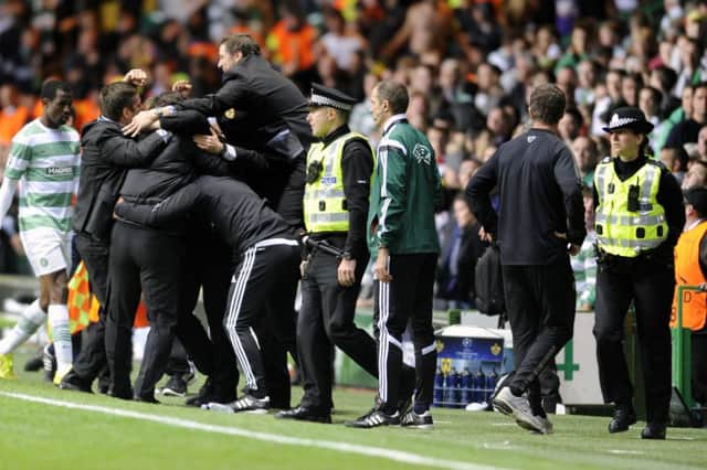 Efe Ambrose trudges towards the tunnel as the Maribor contingent wildly celebrate their 1-0 victory. Picture: John Devlin