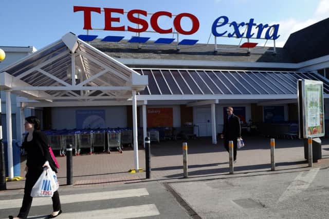 People carry shopping bags through the carpark of a Tesco Extra supermarket in Birkenhead, north-west England. Picture: Getty