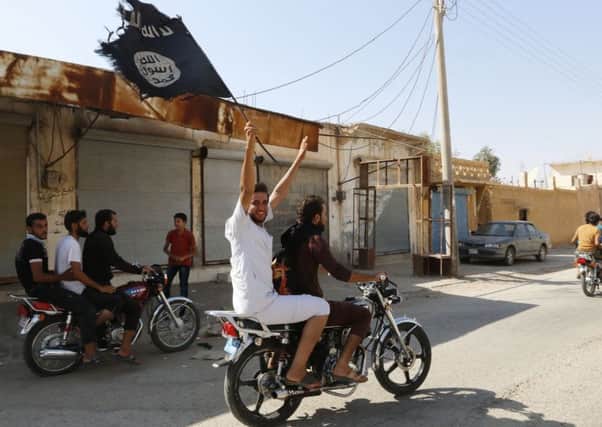 A resident of Tabqa city touring the streets on a motorcycle waves an Islamist flag in celebration after Islamic State militants took over Tabqa air base, in nearby Raqqa city. Picture: Reuters
