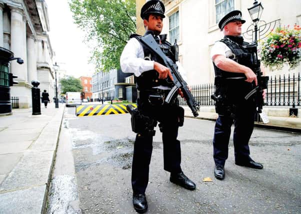 Armed police officers hold guns as they stand in Downing Street. Picture: Getty