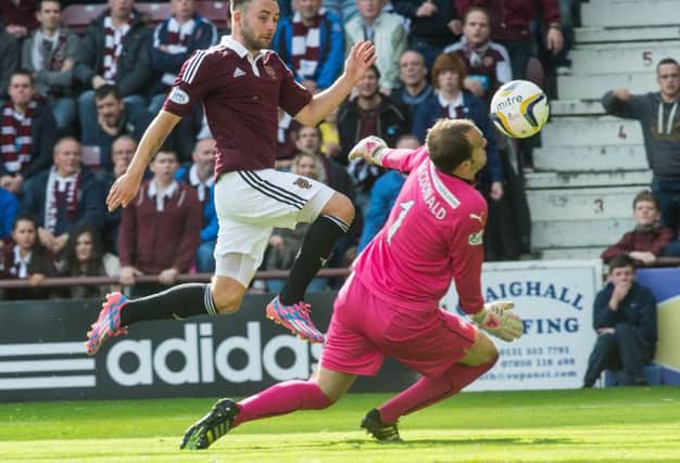 Hearts striker James Keatings attempts to lift the ball over Falkirk goalkeeper Jamie MacDonald at Tynecastle. Picture: Ian Georgeson