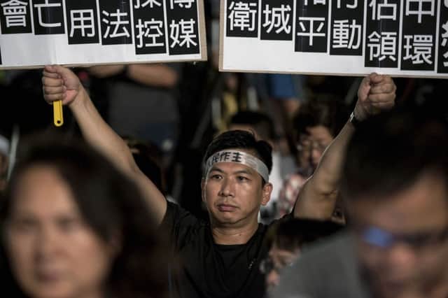 A protester holds placards at a prodemocracy rally held yesterday next to the Hong Kong government complex. Picture:Getty Images