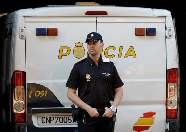A policeman stands guard as a police van allegedly holding Brett and Naghemeh King, parents of five years old Ashya King, at Madrid's National Court. Picture: Getty