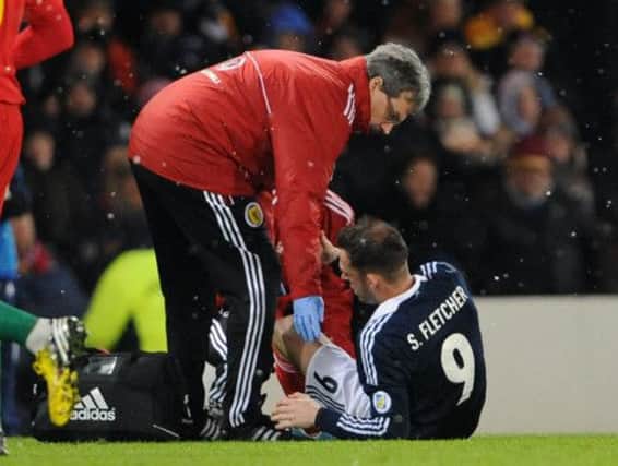 Fletcher receives treatment in World Cup qualifier versus Wales. Picture Ian Rutherford
