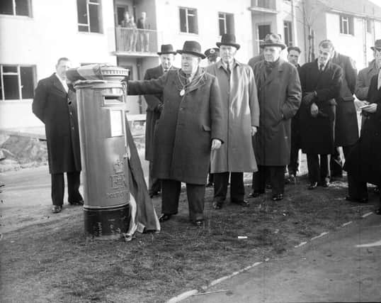 The first letter is posted through the new post box which was first in the UK to bear  the insignia of Queen Elizabeth II. Picture: TSPL