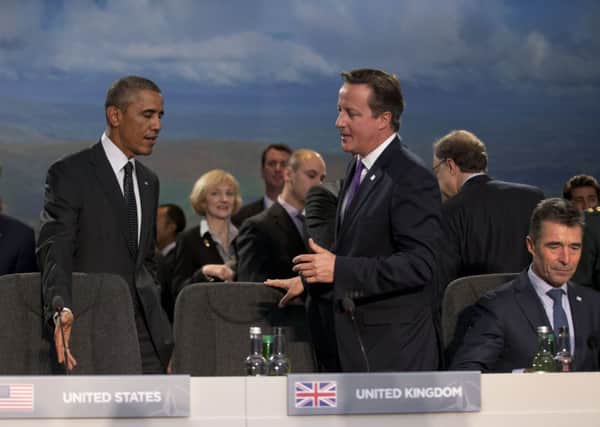 US President Barack Obama and British Prime Minister David Cameron, center, speak before taking their seats beside Nato Secretary General Anders Fogh Rasmussen. Picture: AP