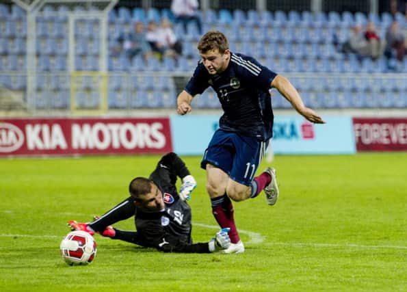 Ryan Fraser rounds keeper Dobrivoj Rusov to open the scoring for Scotland. Picture: SNS