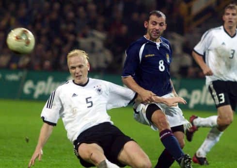 Colin Cameron goes for ball alongside Germany's Carsten Ramelow. Picture: SNS