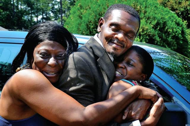 Tracey O'Neal, right, and her sister Michelle Wallace hug their cousin Henry McCollum as he arrives at his sister's home in Fayetteville, N.C. Picture: Getty