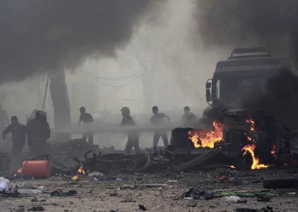 Residents struggle to put out a fire yesterday caused by an air strike on Tal Abyad street market in central Raqqa. Photograph: Reuters