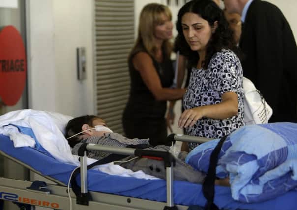 Ashya arrives with his mother Naghemeh at the Motol hospital in Prague. Right: he is carried in on a stretcher having left the Madrid hospital in an ambulance. Main picture: Reuters