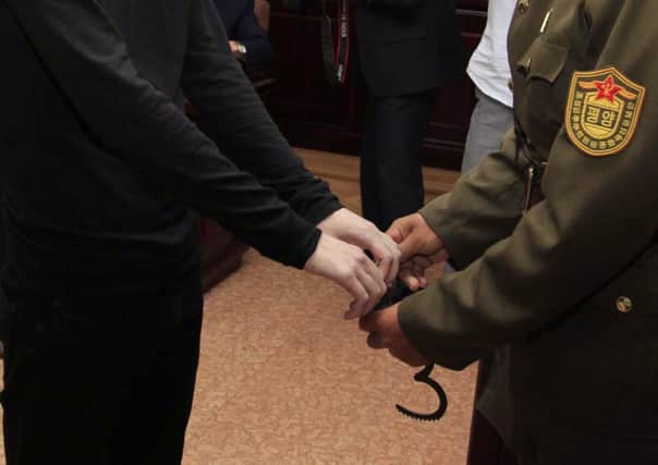Matthew Miller is handcuffed before being led from the Pyongyang courtroom. Picture: AP