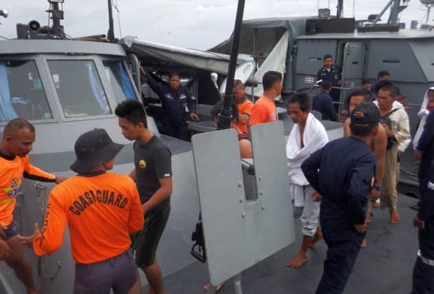 Coastguard officers assist survivors from the stricken ferry as they arrive at Surigao City in the Philippines. Picture: AFP/Getty