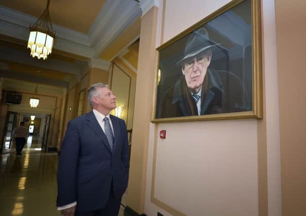 Peter Robinson stands before Ian Paisley's portrait in Stormont's Great Hall. Picture: Getty