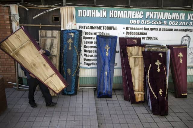 A coffin is carried out of a recently shelled undertakers showroom in the rebelheld city of Donetsk. Picture: Reuters