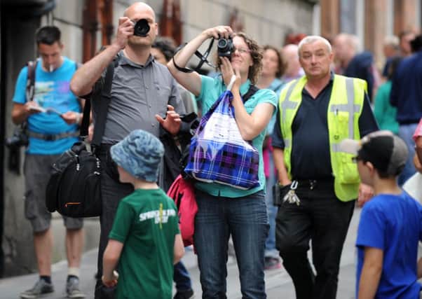 Tourists take pictures on Edinburgh's Royal Mile. Picture: Jane Barlow