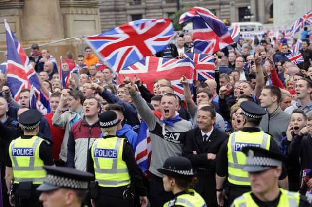 Demonstrators gesture beside police during tonight's demonstration in George Square. Picture: Reuters