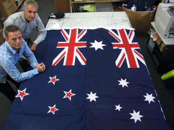 Flagmakers Victor Gizzi, left, and David Moginie, with New Zealand and Australian flags. Picture: Getty