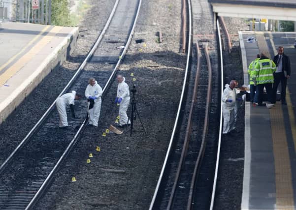 Forensic officers work on the tracks at Slough train station after a woman and a child died after being struck by a train at the station. Picture: PA