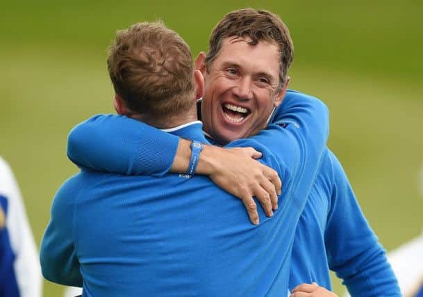 Lee Westwood celebrates with Jamie Donaldson on the 18th green after winning their foursomes match. Picture: Ian Rutherford