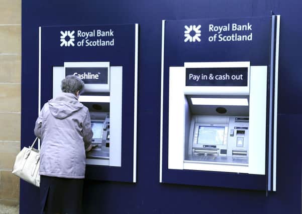 A customer takes money out at an RBS ATM. The bank now believes the problems have been resolved. Picture: Michael Gillen