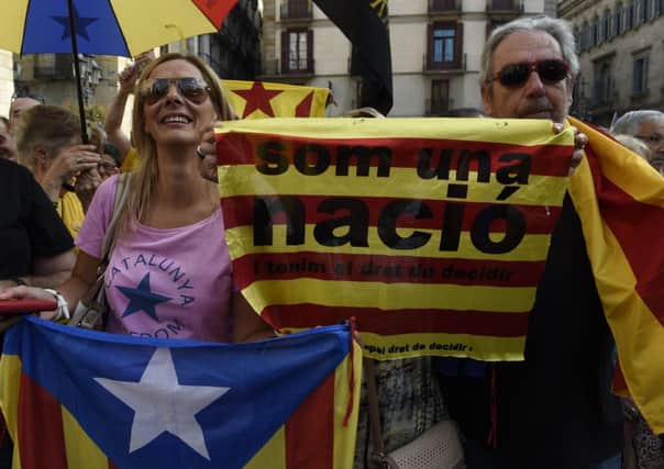 Independence supporters wave flags saying in Catalan, We are a nation and have the right to decide at the rally. Photograph: Lluis Gene/Getty