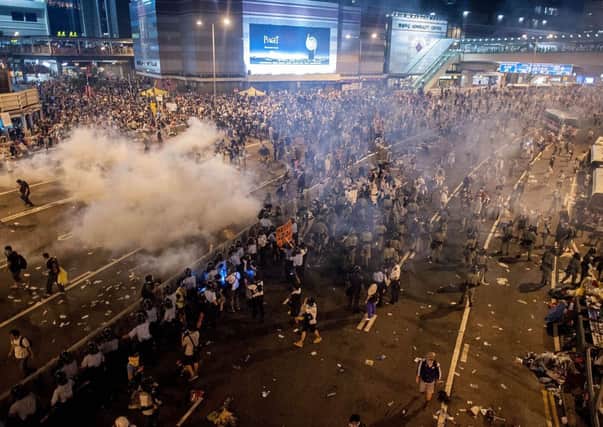 Clouds of tear gas hang over the protesters massed on a main Hong Kong thoroughfare. Picture: Getty