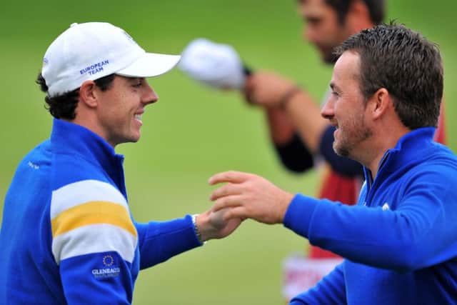 Graeme McDowell of Northern Ireland (R) celebrates after winning his singles match with team-mate Rory McIlroy. Picure: Getty