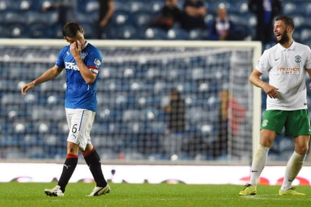 Rangers Lee McCulloch, left, cuts a dejected figure while Hibs Jordon Forster is all smiles at Ibrox. Picture: SNS