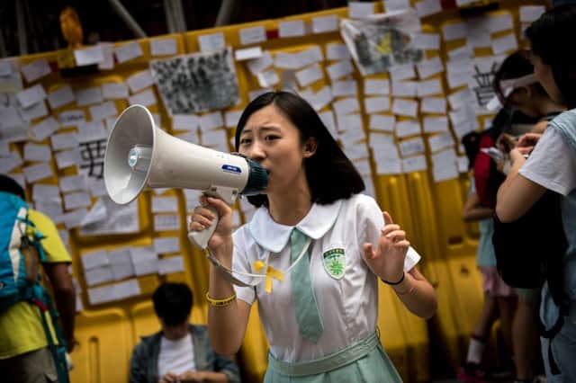 A girl in a school uniform urges people to write notes of support and their hopes for prodemocracy protests in Hong Kong. Picture: Getty